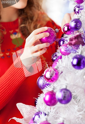 Image of Owner Decorating Christmas Tree With Balls