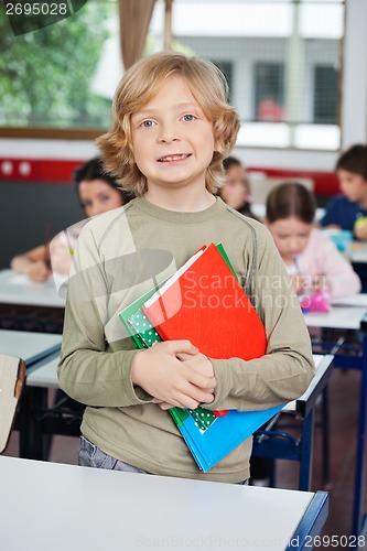 Image of Schoolboy With Books Standing At Desk