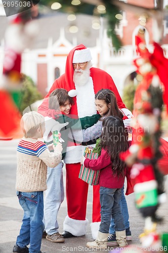 Image of Children Embracing Santa Claus