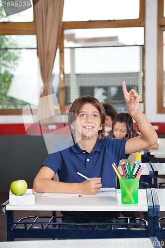 Image of Happy Schoolboy Raising Hand In Classroom