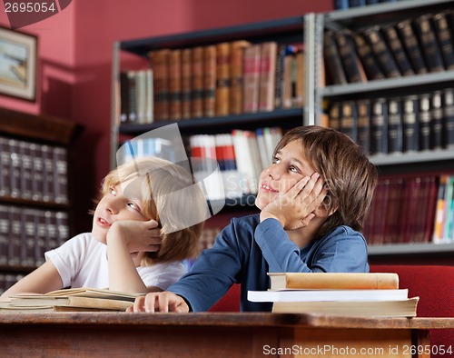 Image of Schoolboys Looking Away While Sitting In Library