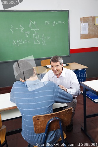 Image of Teenage Boy Studying While Teacher Looking At Him