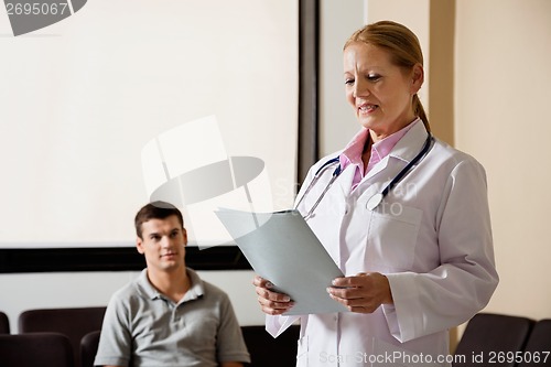 Image of Female Doctor Looking At File