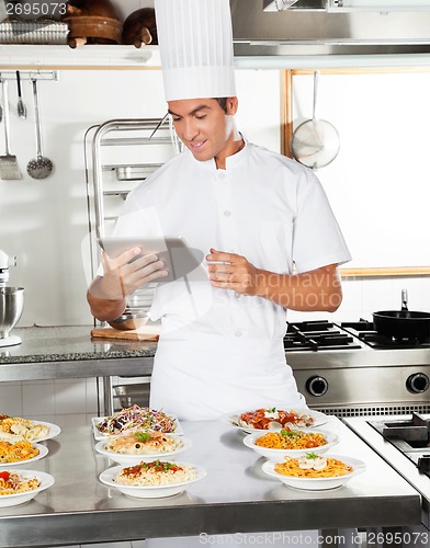 Image of Happy Chef Using Digital Tablet