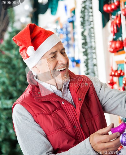 Image of Owner In Santa Hat Working At Christmas Store