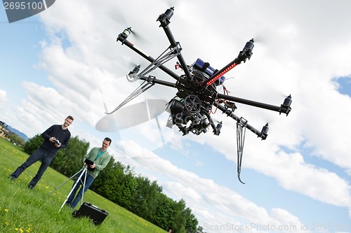 Image of Technicians Operating UAV Helicopter in Park