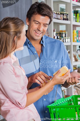 Image of Woman Showing Cheese To Man In Supermarket