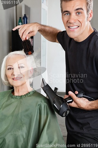 Image of Hair Stylist Blow Drying Senior Woman's Hair