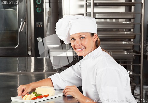 Image of Female Chef With Dish At Counter