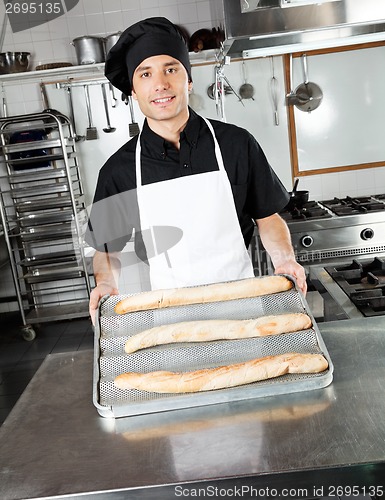 Image of Male Chef Showing Baked Bread Loafs