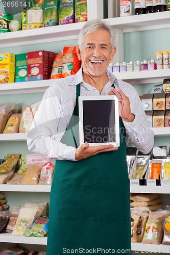 Image of Male Owner Showing Digital Tablet In Store