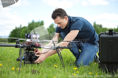 Image of Technician Fixing Camera On UAV Helicopter