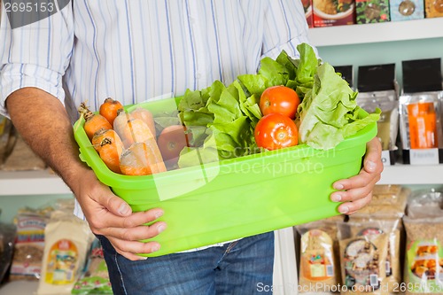 Image of Midsection Of Man Holding Vegetable Basket