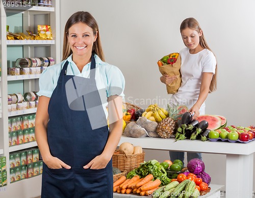 Image of Saleswoman With Female Customer Shopping At Supermarket