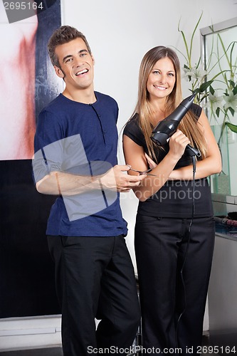 Image of Happy Hairdressers Holding Scissors And Hairdryer
