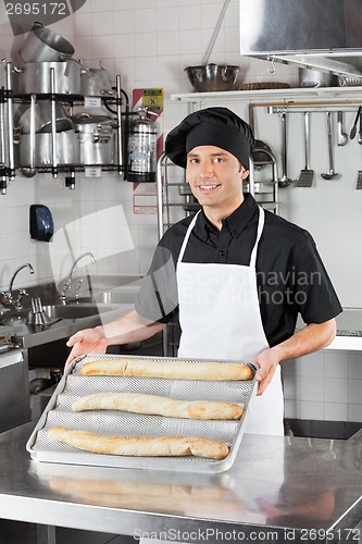 Image of Male Chef Presenting Loafs In Kitchen