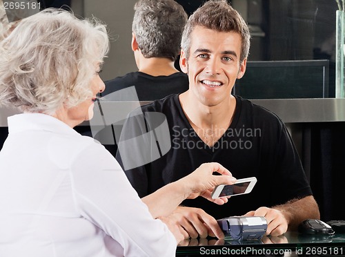 Image of Hairdresser With Woman Paying Through Cellphone