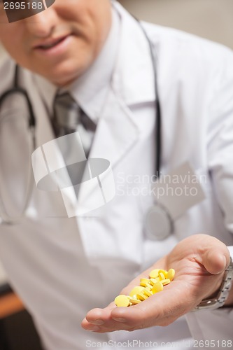 Image of Doctor Holding Yellow Pills