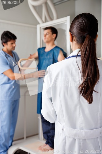 Image of Doctor With Technician Assisting Patient For X-ray