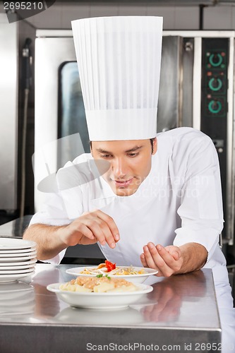 Image of Chef Adding Spices To Dish