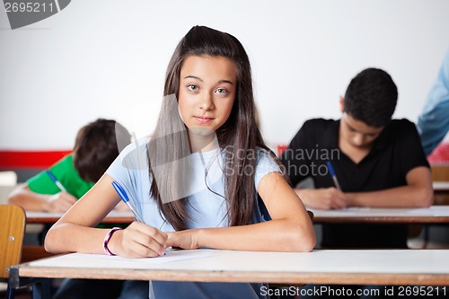 Image of Portrait Of Teenage Schoolgirl Writing At Desk