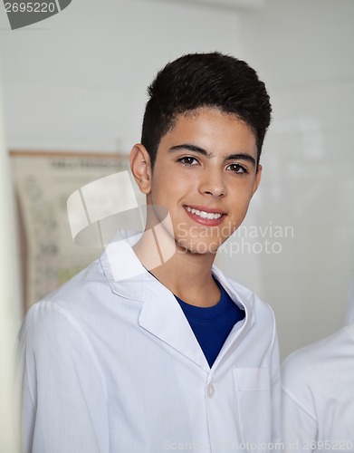Image of Teenage Schoolboy Wearing Labcoat In Science Lab