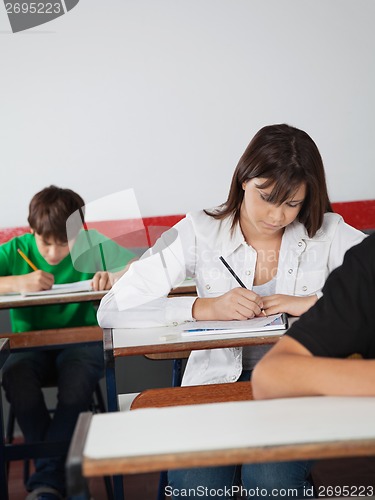 Image of Schoolgirl Writing Paper At Desk