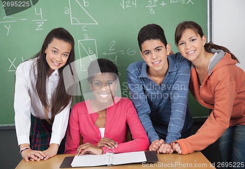 Image of Teacher With High School Students At Desk