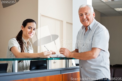 Image of Senior Man Standing At Hospital Reception