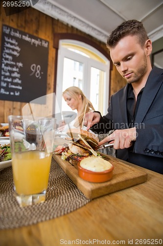 Image of Businessman Having Food With Colleague