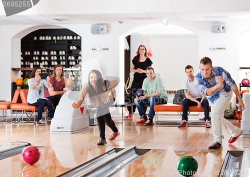Image of Young Friends Playing in Bowling Alley