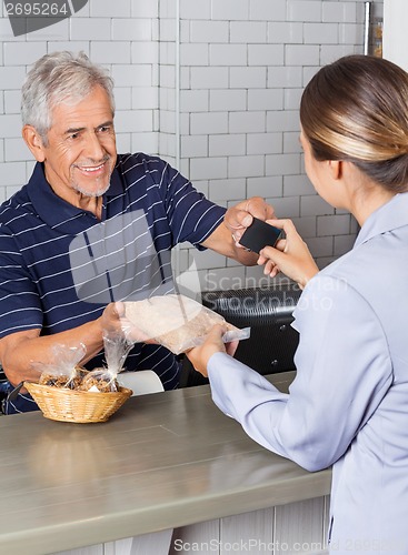 Image of Female Customer Making Credit Card Payment At Counter