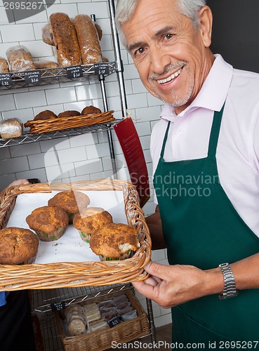 Image of Salesman Displaying Tray Of Cupcakes