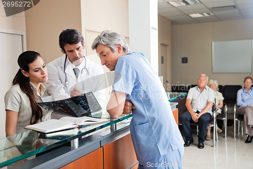 Image of Doctors Reviewing X-ray At Reception