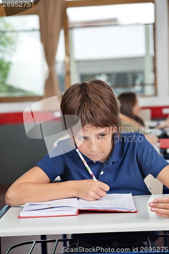 Image of Schoolboy Cheating At Desk During Examination