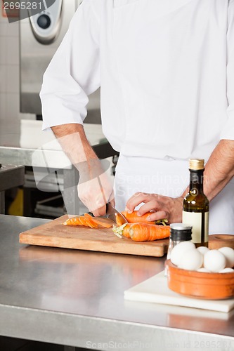 Image of Chef Cutting Carrots At Kitchen Counter