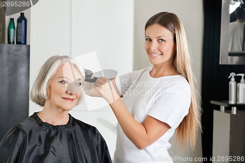 Image of Hairdresser Ironing Customer's Hair