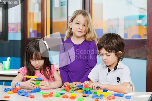Image of Girl With Friends Playing Blocks In Kindergarten
