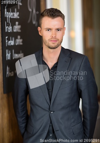 Image of Confident Business man Standing In Coffeeshop