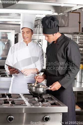Image of Young Chefs With Digital Tablet Preparing Food