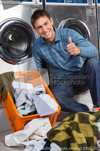 Image of Man Gesturing Thumbs Up At Laundry