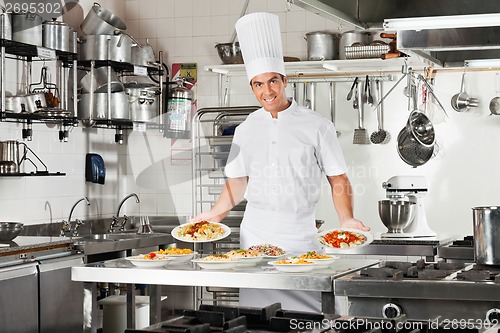 Image of Confident Chef Presenting Pasta Dishes