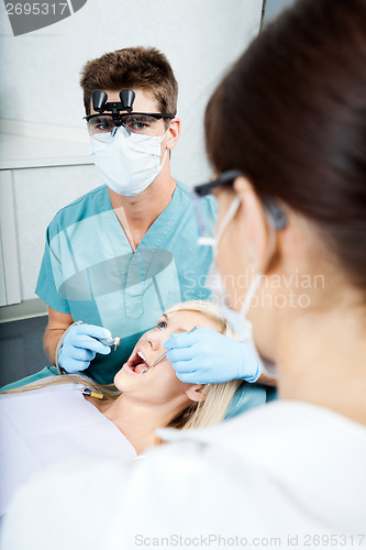 Image of Dentist And Female Assistant Treating A Patient At Clinic