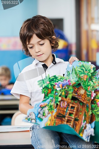 Image of Boy With Popup Book Sitting On Desk In Kindergarten