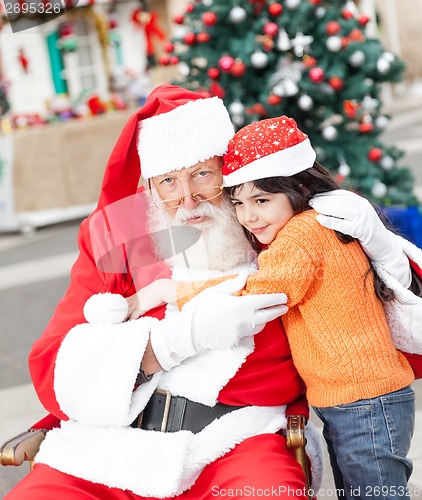 Image of Santa Claus Embracing Girl