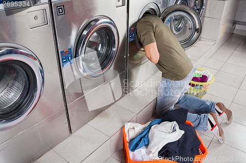 Image of Man Searching Clothes Inside Washing Machine