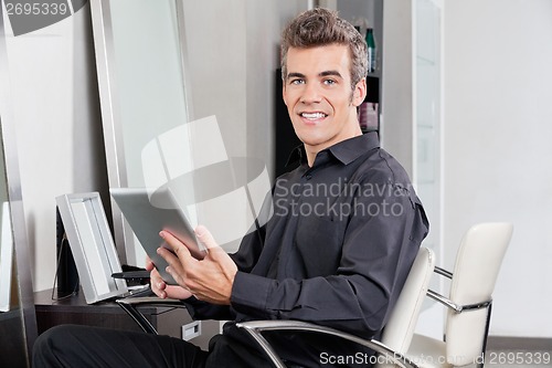 Image of Male Customer With Digital Tablet Sitting At Salon