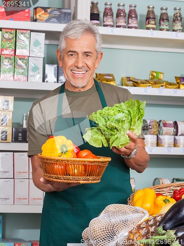 Image of Senior Salesman Selling Vegetables In Store