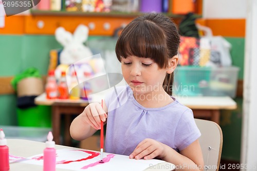 Image of Girl Painting At Desk In Classroom