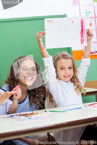 Image of Teacher With Girl Showing Drawing At Desk